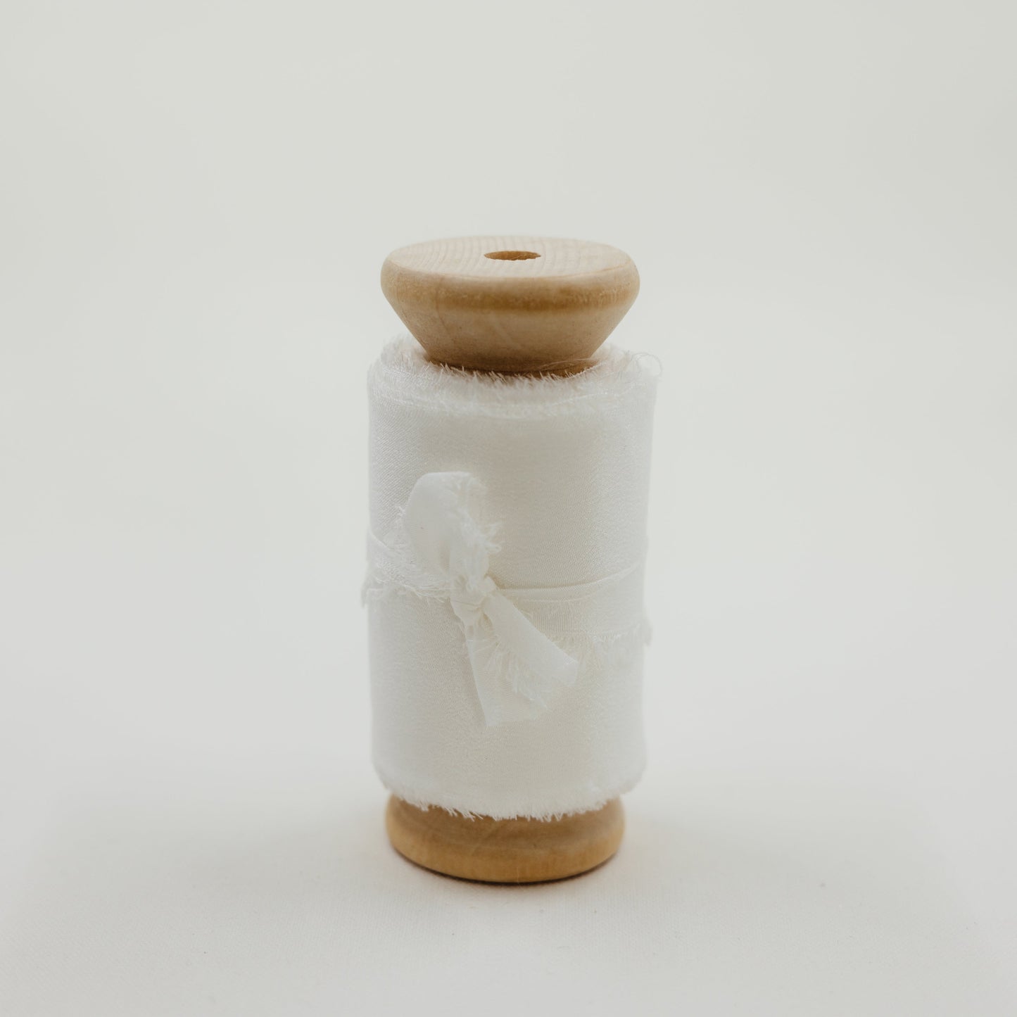 Handmade silk ribbon with a raw edge, used to create soft, flowing lines in bridal flat lay compositions