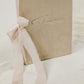 Handmade vow book, featuring a velvet cover in white, silver, or champagne, with 'vows' embossed and a ribbon tie detail