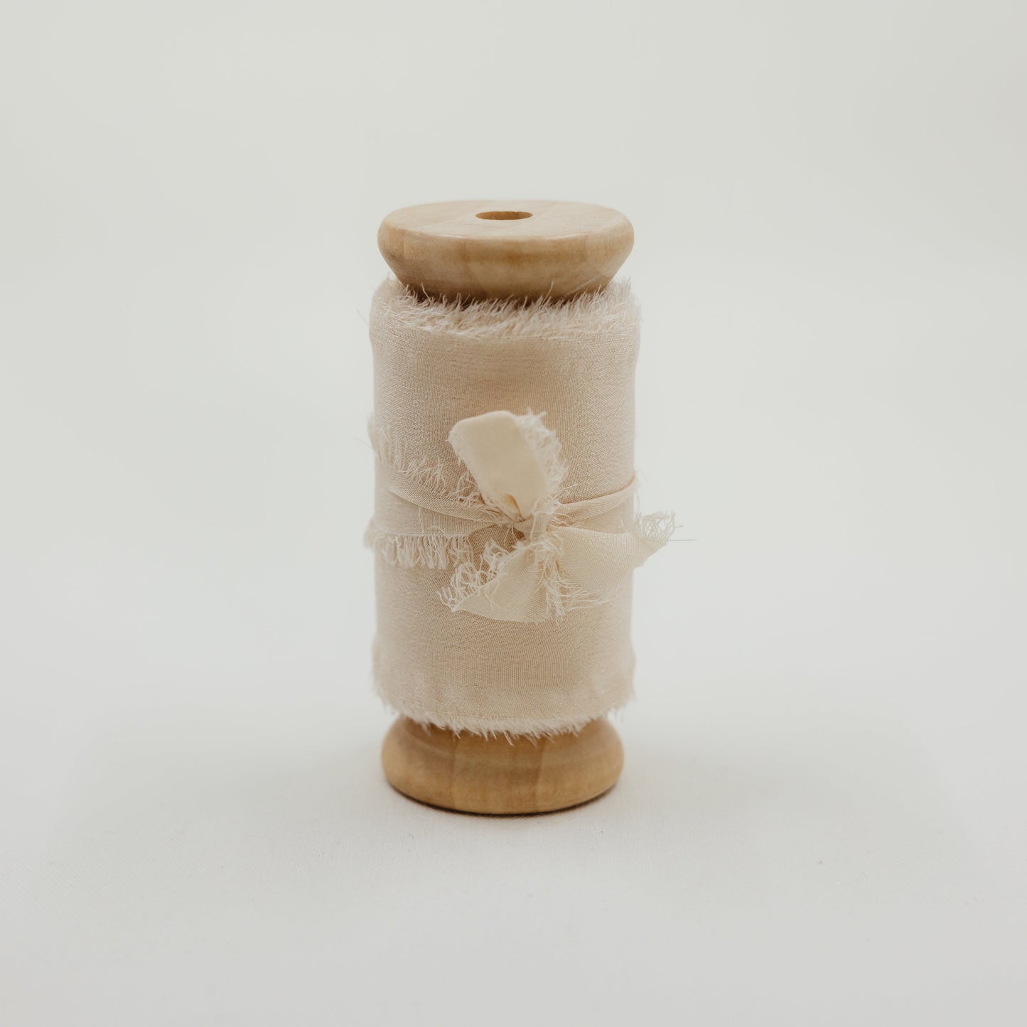 Raw edge, hand-dyed silk ribbon, shown styled in a wedding flat lay with rings and invitation suite