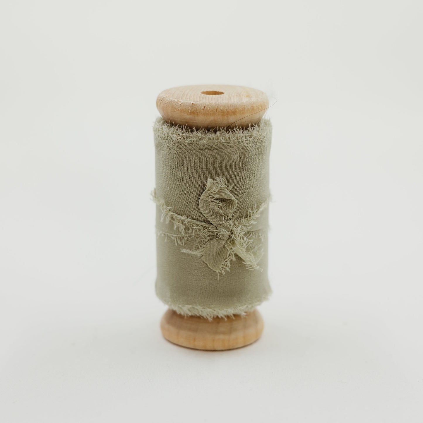 Spool of raw edge silk ribbon in sage color for wedding