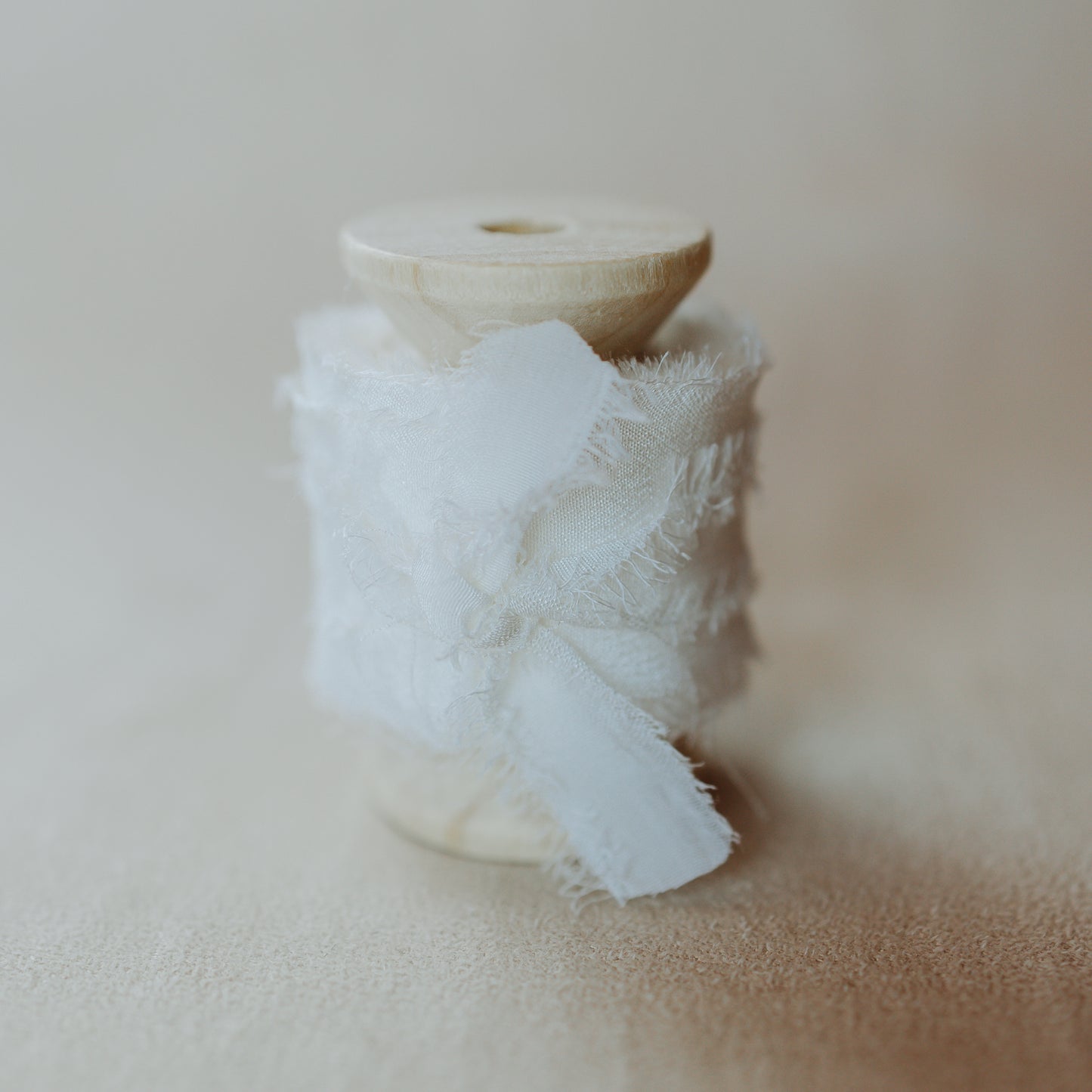 Silk ribbon, hand-dyed and featuring a raw edge, used as a styling element in flat lay images focusing on bridal details and florals